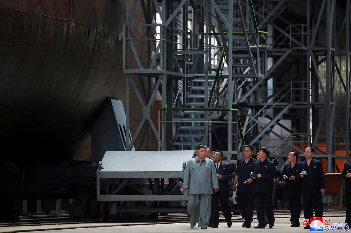 In this undated photo provided on Tuesday, July 23, 2019, North Korean leader Kim Jong Un, left, inspects a newly built submarine to be deployed soon, at an unknown location in North Korea.