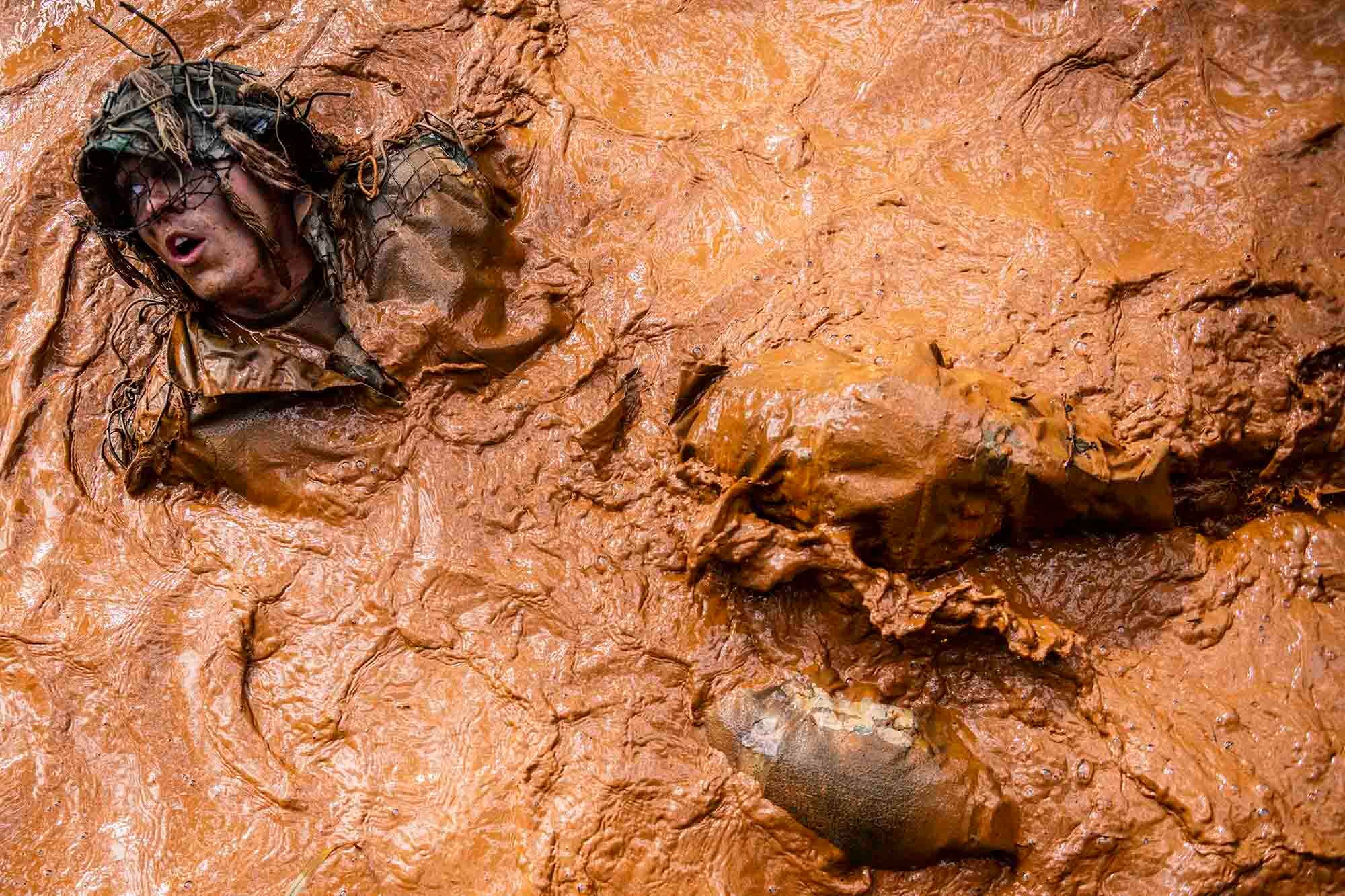 A soldier participates in a ghillie wash during Army Sniper School at Fort Benning, Ga., Feb. 5, 2021. The exercise is designed to test the strength and durability of the camouflage suits as well as weather them.