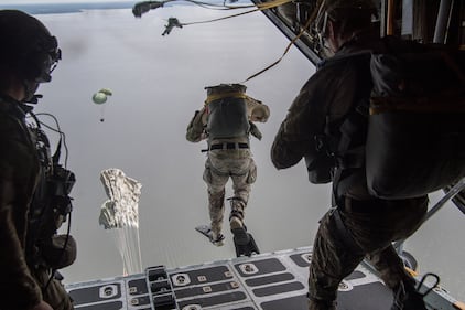 Air Force Special Tactics operators conduct a static line jump out of a C-130H Hercules following a Rigged Alternate Method Boat package into the water during training at Eglin Range, Fla., Aug. 21, 2020.