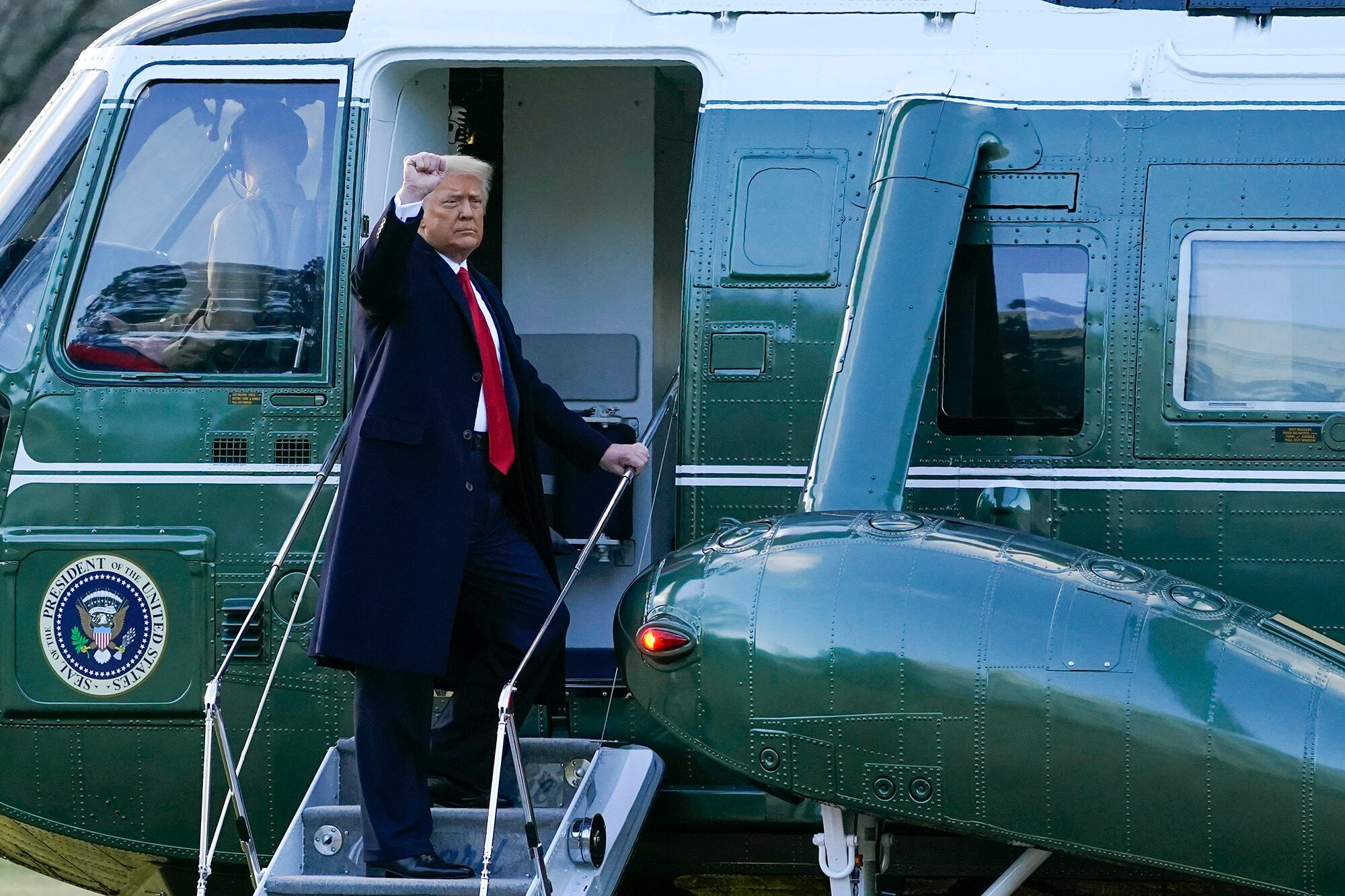 President Donald Trump gestures as he boards Marine One on the South Lawn of the White House, Wednesday, Jan. 20, 2021, in Washington. Trump is en route to his Mar-a-Lago Florida Resort.