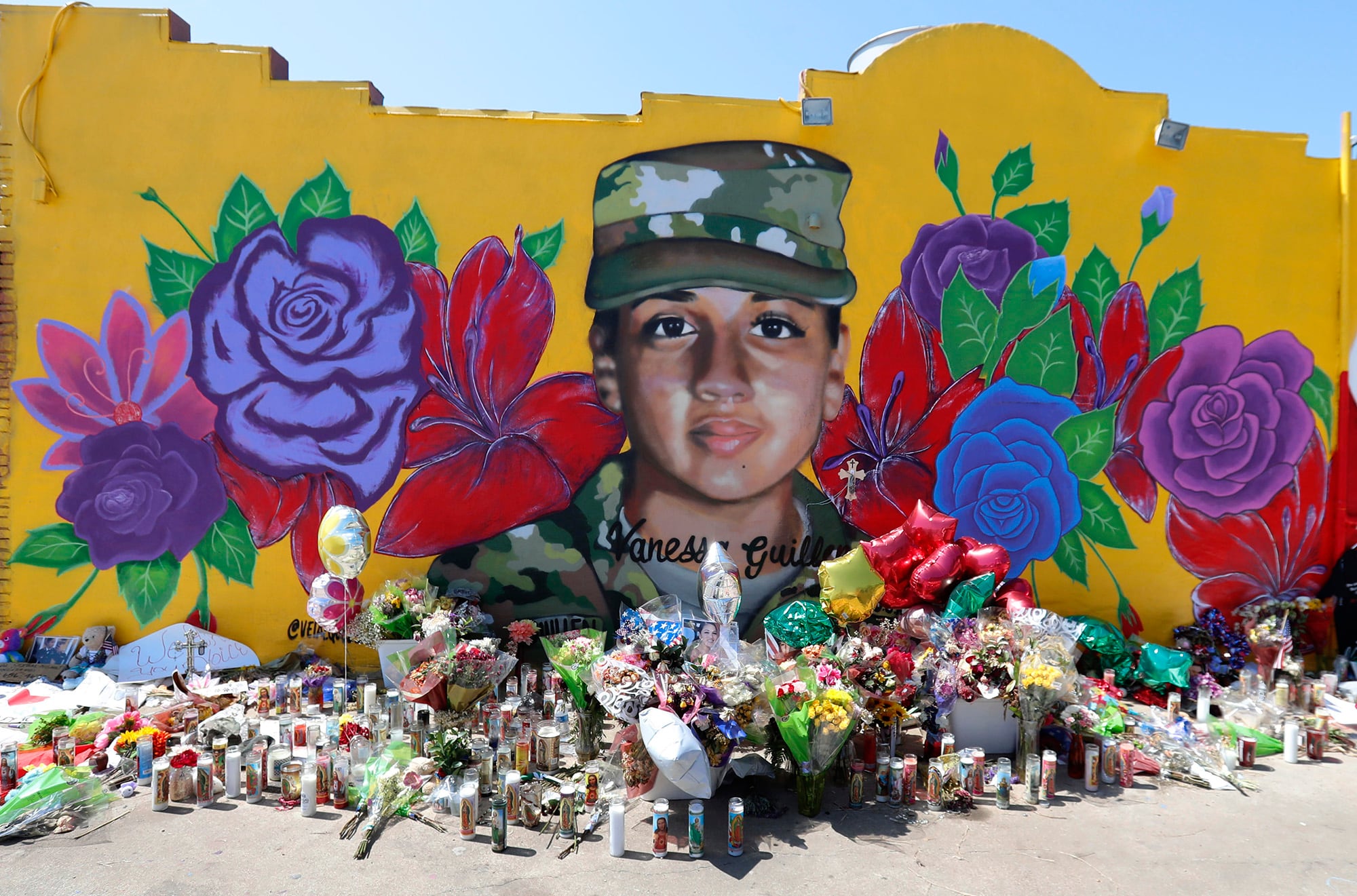 Offerings sit in front of a mural of slain Army Spc. Vanessa Guillen painted on a wall in the south side of Fort Worth, Texas, July 11, 2020.