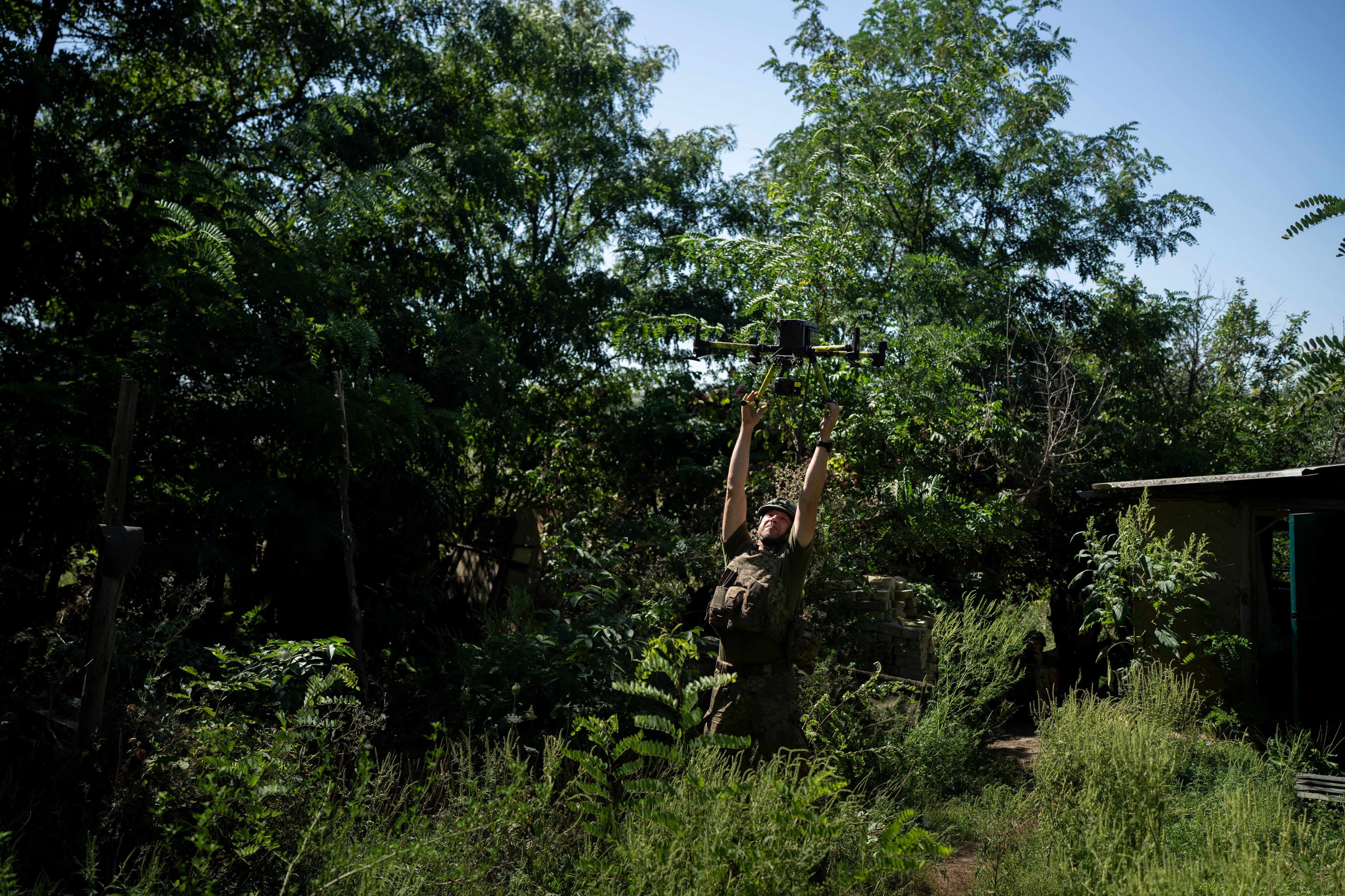 A Ukrainian solider grabs an intelligence drone during landing in the Luhansk region, Ukraine, Saturday, Aug. 19, 2023.