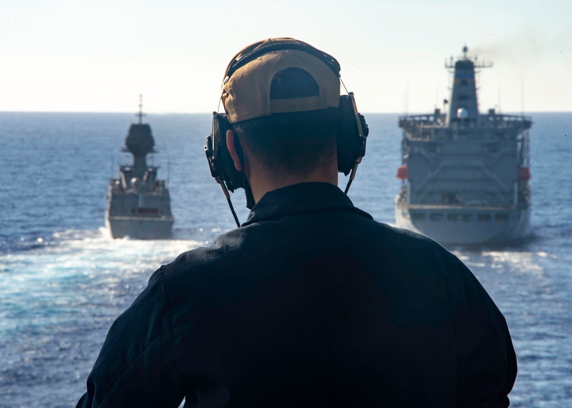 U.S. Navy Seaman Keith Vang stands forward lookout watch aboard U.S. Navy Wasp-class amphibious assault ship USS Essex (LHD 2) as Royal Australian Navy ship HMAS Arunta (FFH 151) transits the Pacific Ocean alongside U.S. Navy fleet replenishment oiler USNS Henry J. Kaiser (T-AO 187) on Aug. 17 during Exercise Rim of the Pacific (RIMPAC) 2020.