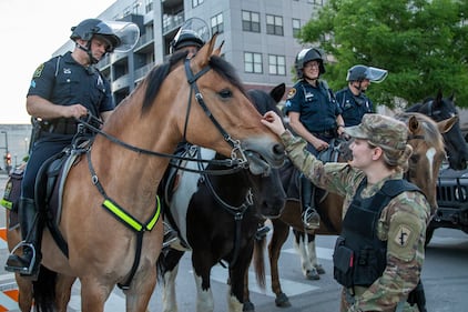 Soldiers with the Nebraska Army National Guard engage with Omaha Police Mounted Patrol Unit officers and their horses June 2, 2020, in downtown Omaha.