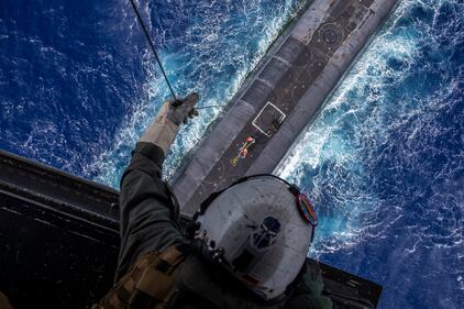 Staff Sgt. Ruben Arzate lowers a payload from an MV-22B Osprey to the Ohio-class ballistic-missile submarine USS Henry M. Jackson (SSBN 730) in the vicinity of the Hawaiian Islands on Oct. 21, 2020.