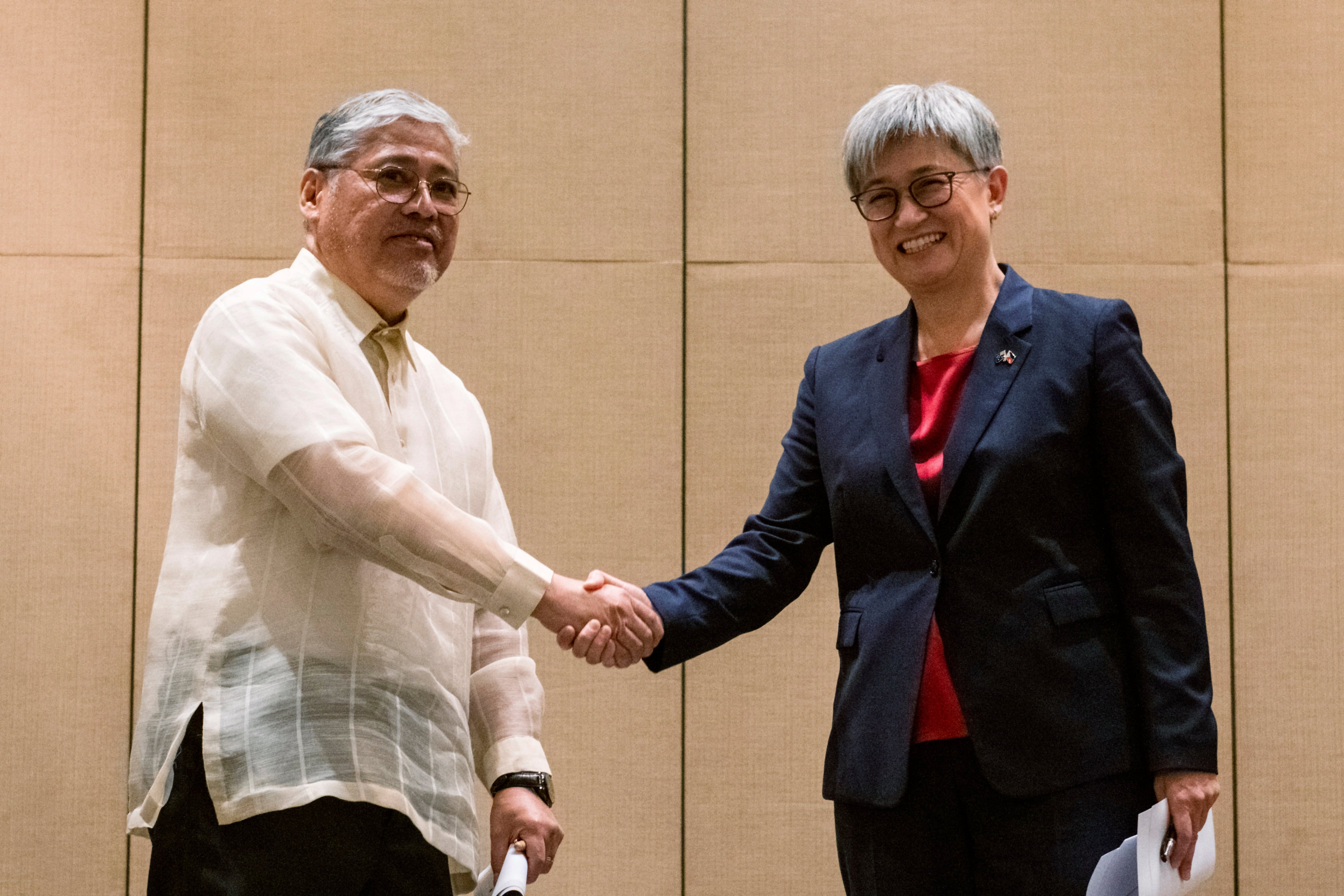 Australian Foreign Minister Penny Wong, right, shakes hands with Philippine Foreign Affairs Secretary Enrique Manalo during a joint press conference at a hotel in Makati City, Philippines on Thursday May 18, 2023.