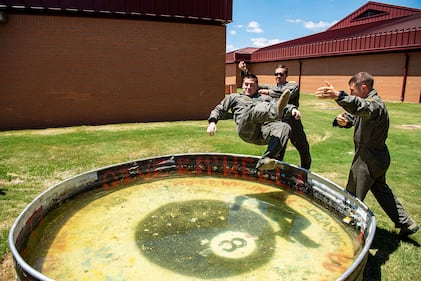 2nd Lt. Corey Persons is thrown into a solo tank by fellow student pilots 2nd Lt. Graham McAninich and 2nd Lt. Kyle Blanchette on July 15, 2019, at Vance Air Force Base, Okla. It is Air Force tradition to be thrown into the solo tank upon completion of a student pilot’s first solo flight.