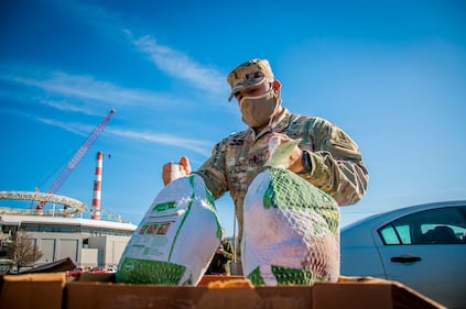 U.S. Army 1st Lt. Edwin Escobar, assigned to the Connecticut National Guard's 643rd Military Police Company, grabs a couple of turkeys for families during the Bridgeport Rescue Mission's annual Great Thanksgiving Project on Nov. 20, 2020, in Bridgeport, Conn