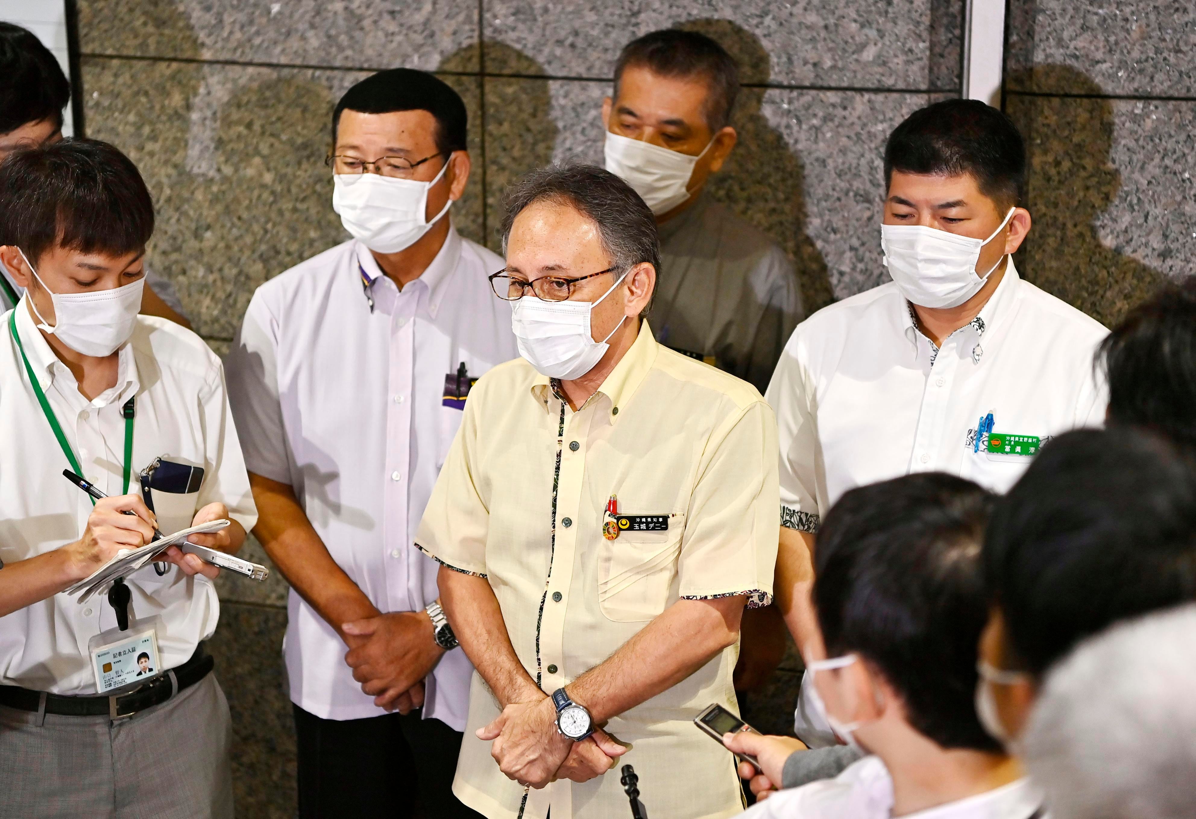 Okinawa Gov. Denny Tamaki, center, speaks to the reporters after meeting with Japanese Defense Minister Taro Kono at the Defense Ministry in Tokyo on July 15, 2020.