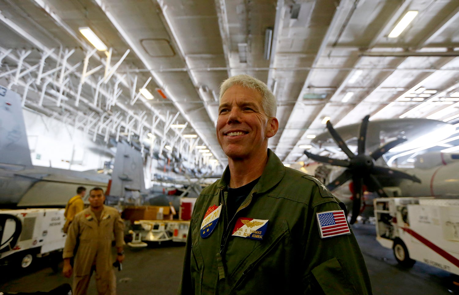 Rear Adm. Karl Thomas, Task Force 70/commander, Carrier Strike Group 5, poses before an E-2 Hawkeye plane following a media interview aboard the U.S. aircraft carrier USS Ronald Reagan off South China Sea on Aug. 6, 2019.