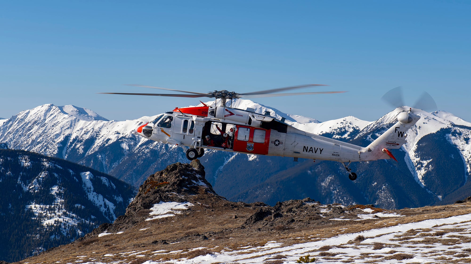 An MH-60S Sea Hawk helicopter from Naval Air Station Whidbey Island prepares to land during an Alpine Search and Rescue training mission in the Olympic Mountains on Feb. 19, 2019.