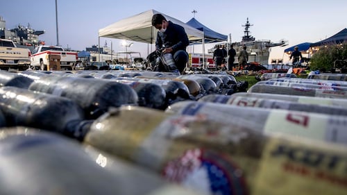 A sailor assigned to the amphibious assault ship USS Bonhomme Richard (LHD 6) inspects firefighting gear at Naval Base San Diego on July 15, 2020.