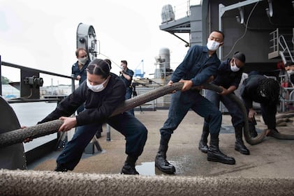 Sailors heave a mooring line on the fantail of the Navy's only forward-deployed aircraft carrier, the USS Ronald Reagan (CVN 76), in preparation to get the ship underway on May 21, 2020, in Yokosuka, Japan.