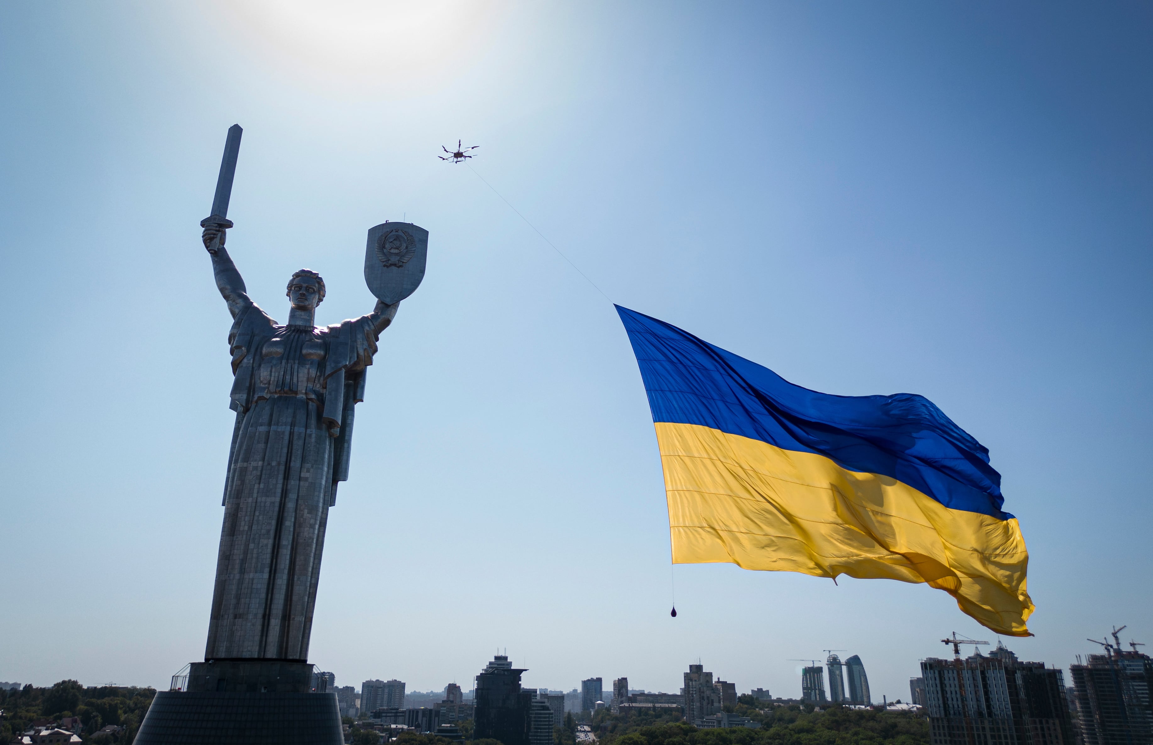 A drone carries a big national flag in front of Ukraine's the Motherland Monument in Kyiv, Ukraine, Wednesday, Aug. 24, 2022.