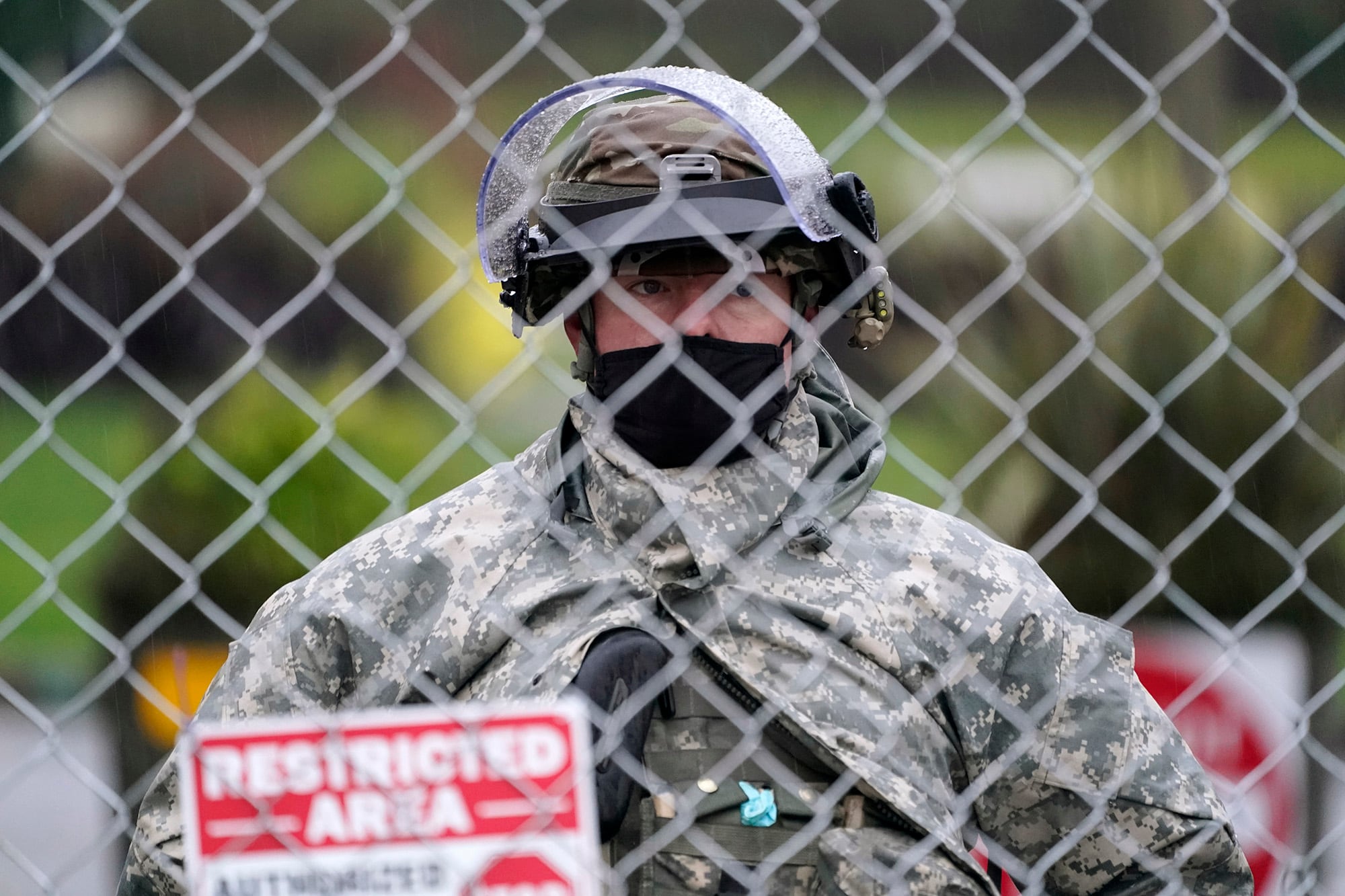 A member of the Washington National Guard stands at a fence surrounding the Capitol in anticipation of protests Monday, Jan. 11, 2021, in Olympia, Wash.