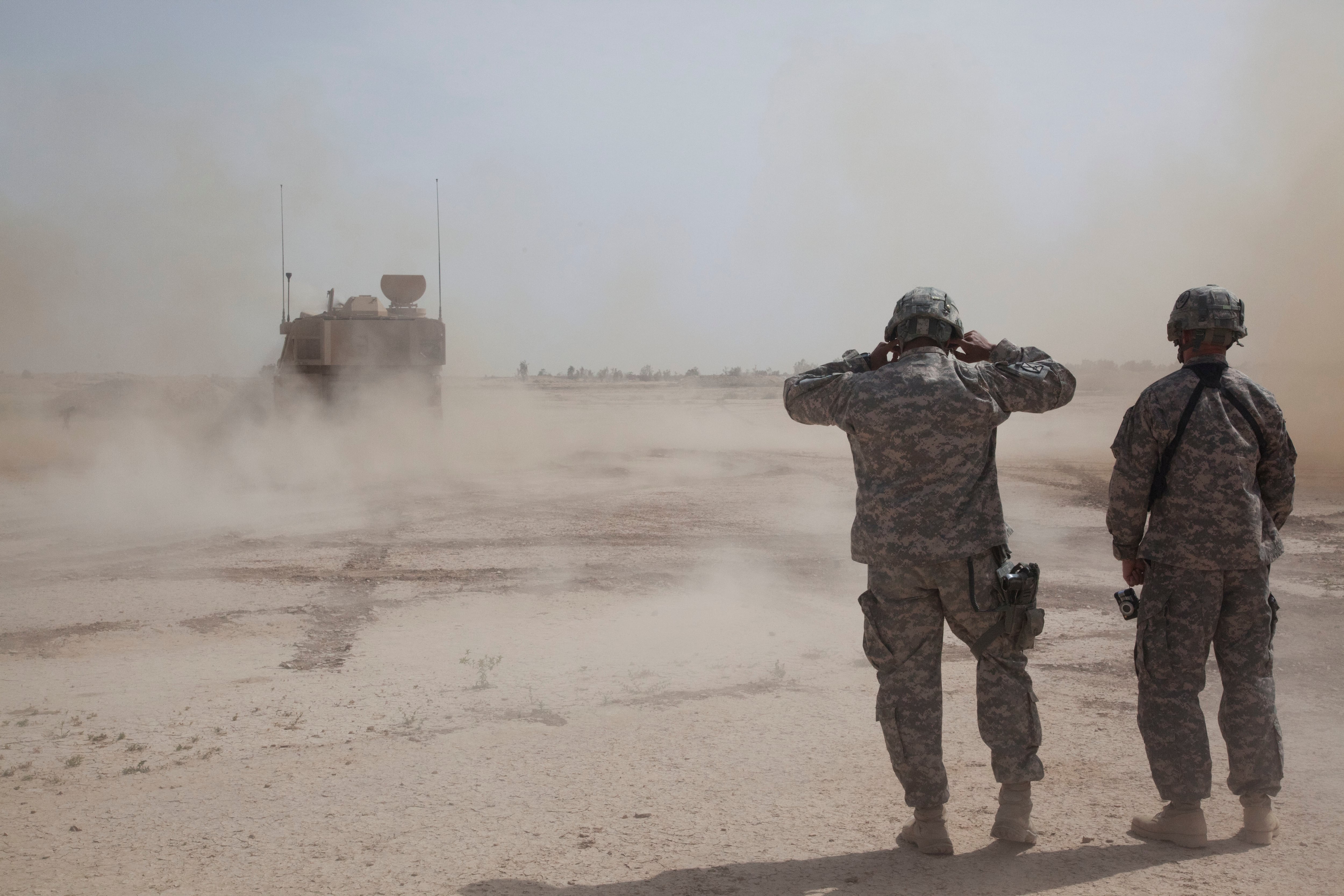 Soldiers cover their ears during an artillery qualification at Besamaya Range in Forward Operating Base Hammer, Iraq.