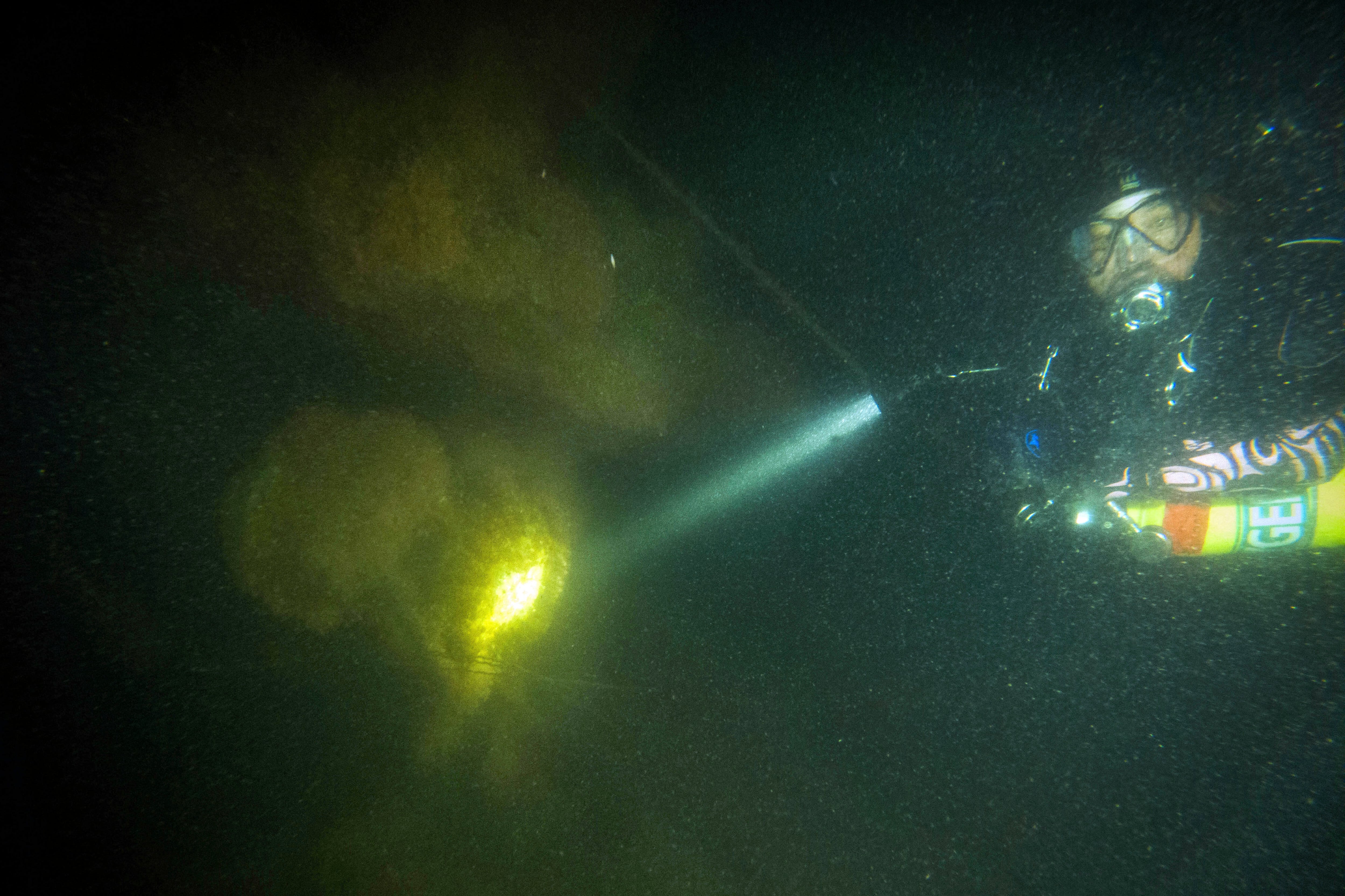 This photo, provided by Shoreline Diving Services, shows diver Steve Abbate inspecting a propeller, Sunday, April 16, 2023, of the 92-foot attack submarine Defender that was scuttled by the Army Corp of Engineers in 1946.