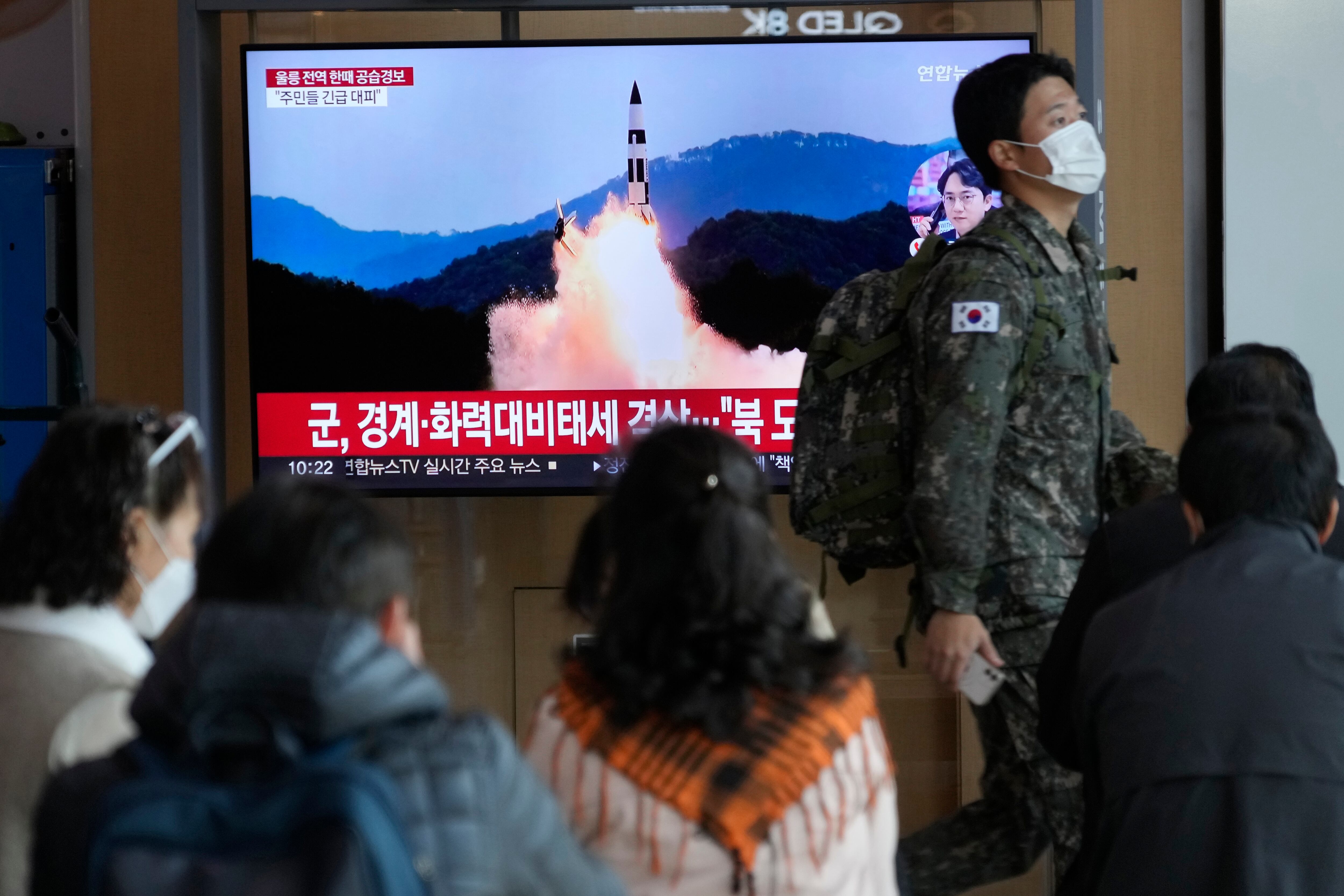 A South Korean army soldier passes by a TV screen showing a file image of North Korea's missile launch during a news program at the Seoul Railway Station in Seoul, South Korea, Wednesday, Nov. 2, 2022.