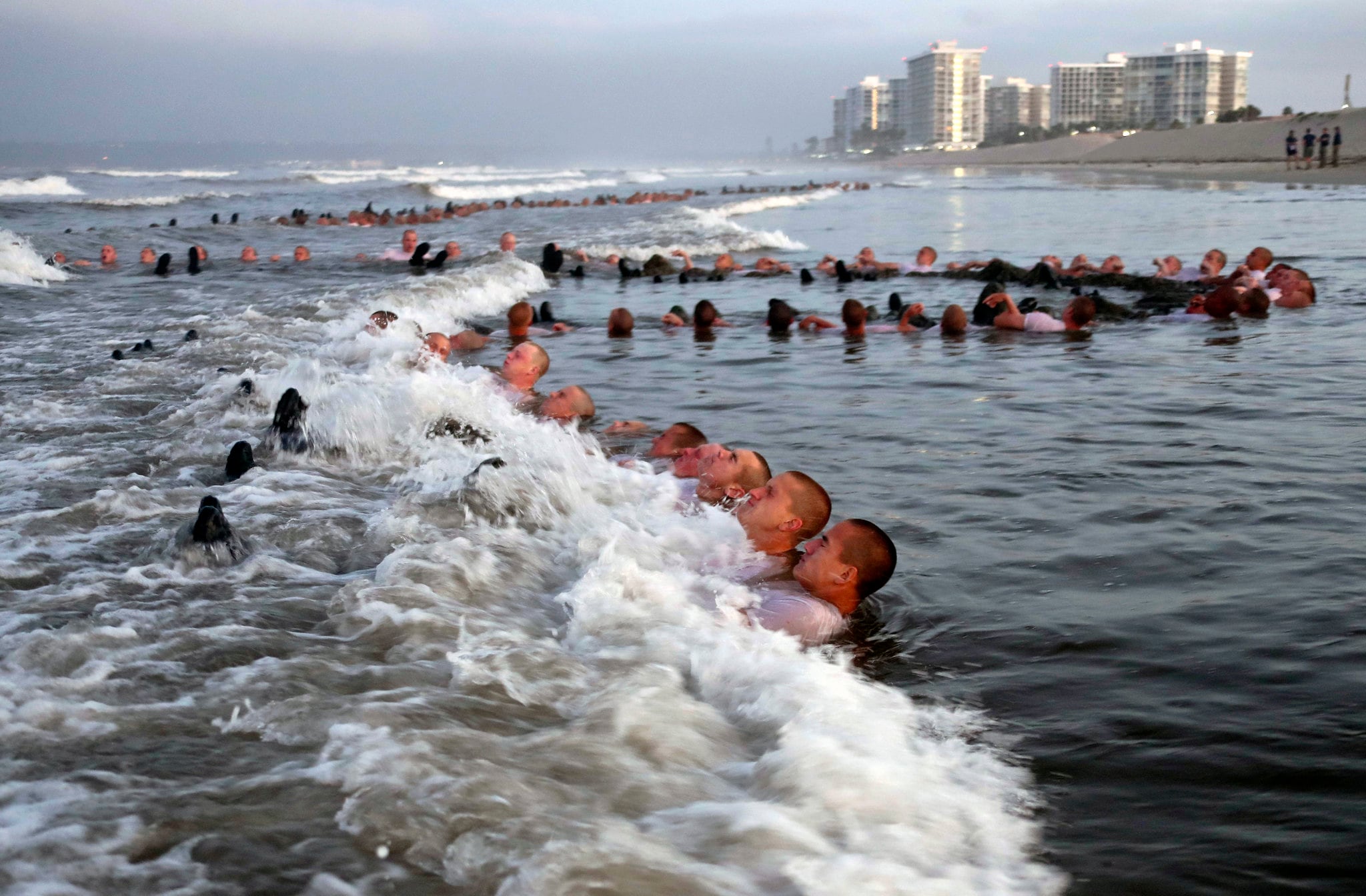 Navy SEAL candidates participate in surf immersion during Basic Underwater Demolition/SEAL (BUD/S) training at Naval Special Warfare (NSW) Center