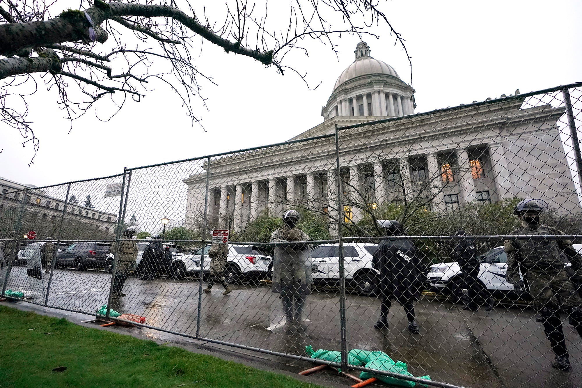 Members of the Washington National Guard stand near a fence surrounding the Capitol in anticipation of protests Monday, Jan. 11, 2021, in Olympia, Wash.