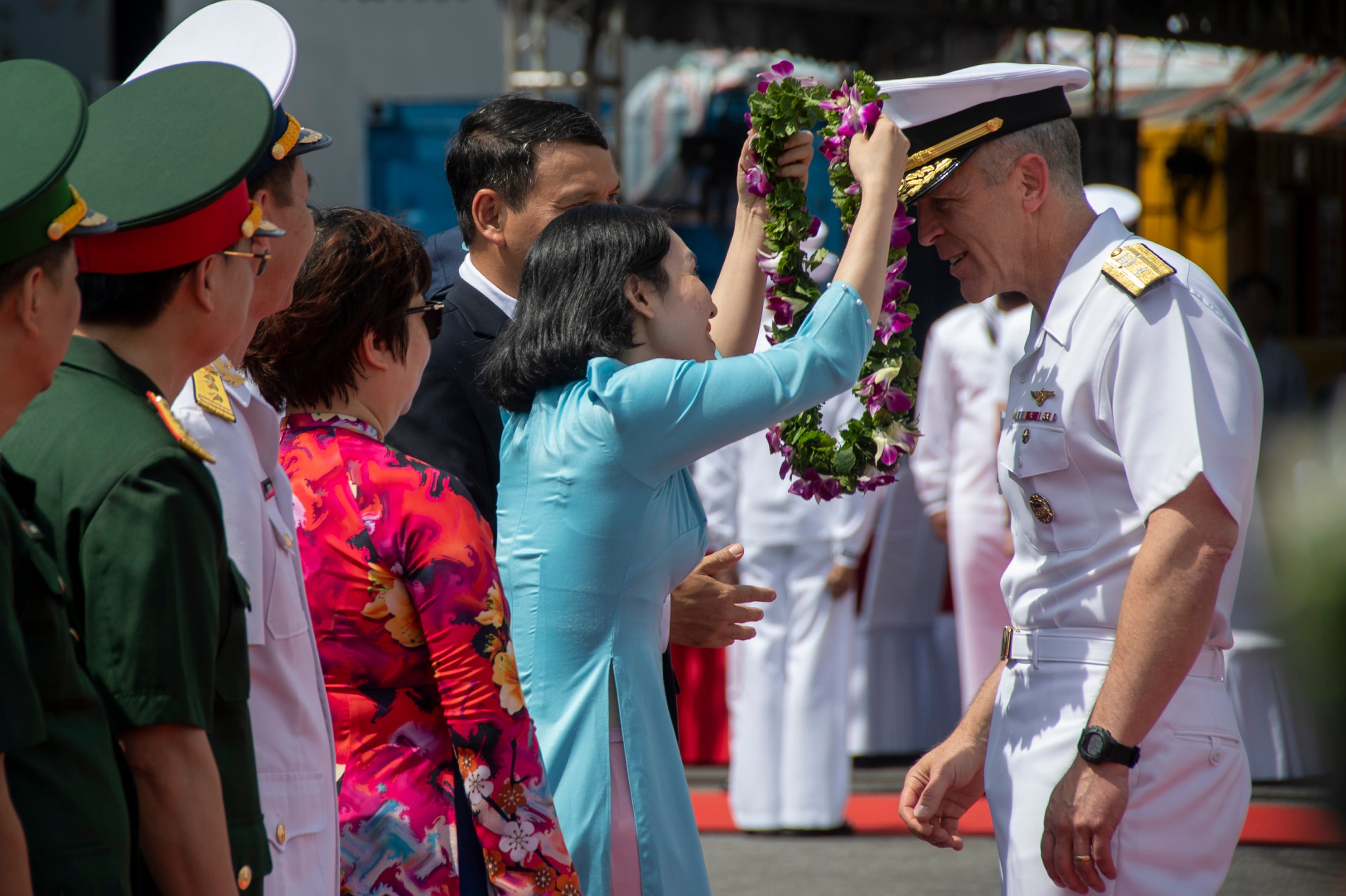 In this photo provided by U.S. Navy, Rear Adm. Pat Hannifin, right, receives a wreath during a welcome ceremony after the aircraft carrier Ronald Reagan, anchored into Da Nang, Vietnam, for a routine port visit, Sunday, June 25, 2023.