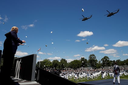 President Donald Trump applauds as Army helicopters fly over and West Point cadets toss their caps into the air at the end of commencement ceremonies on the parade field, at the United States Military Academy in West Point, N.Y., Saturday, June 13, 2020.