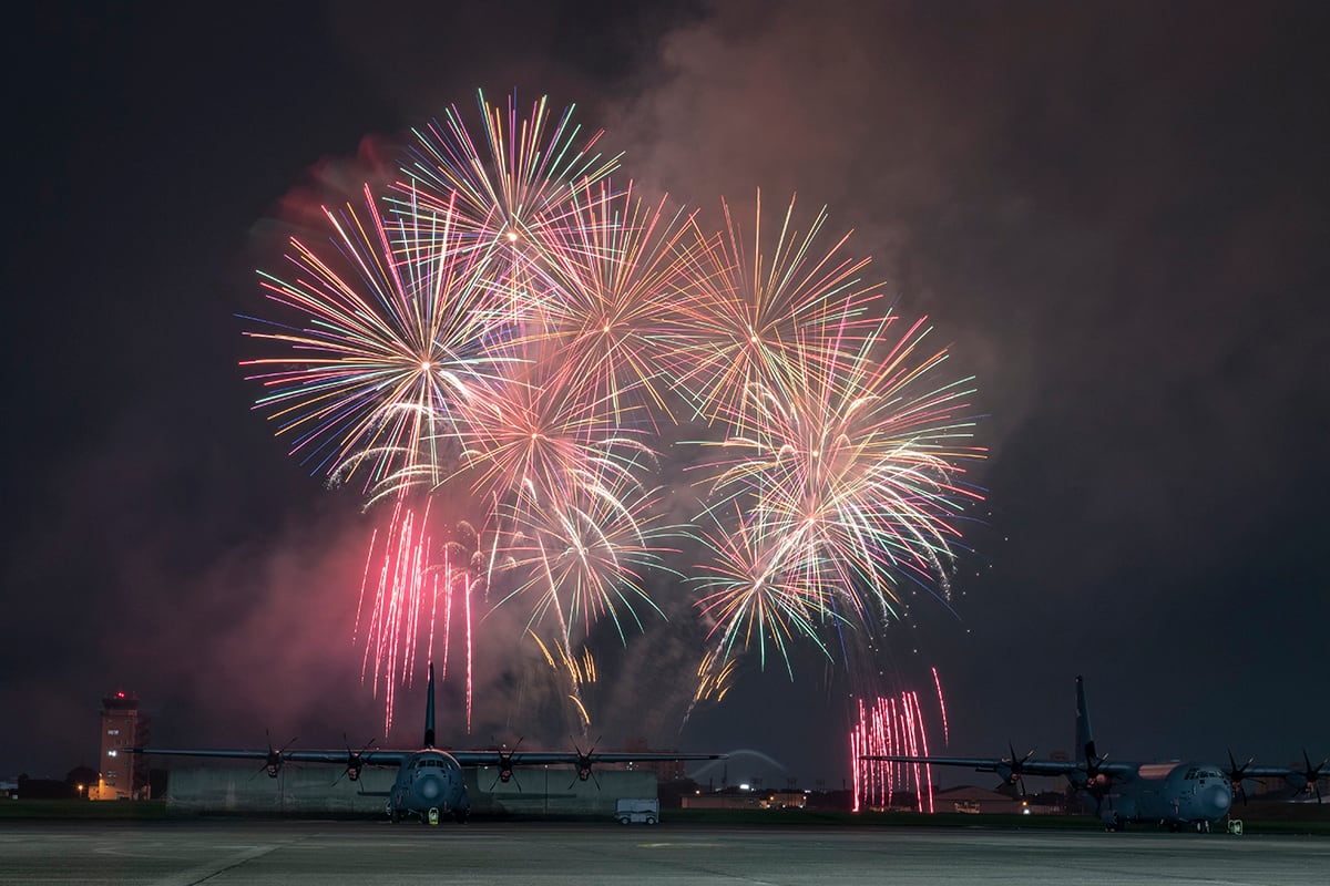 Fireworks explode behind a C-130J Super Hercules during Celebrate America at Yokota Air Base, Japan, July 3, 2019.