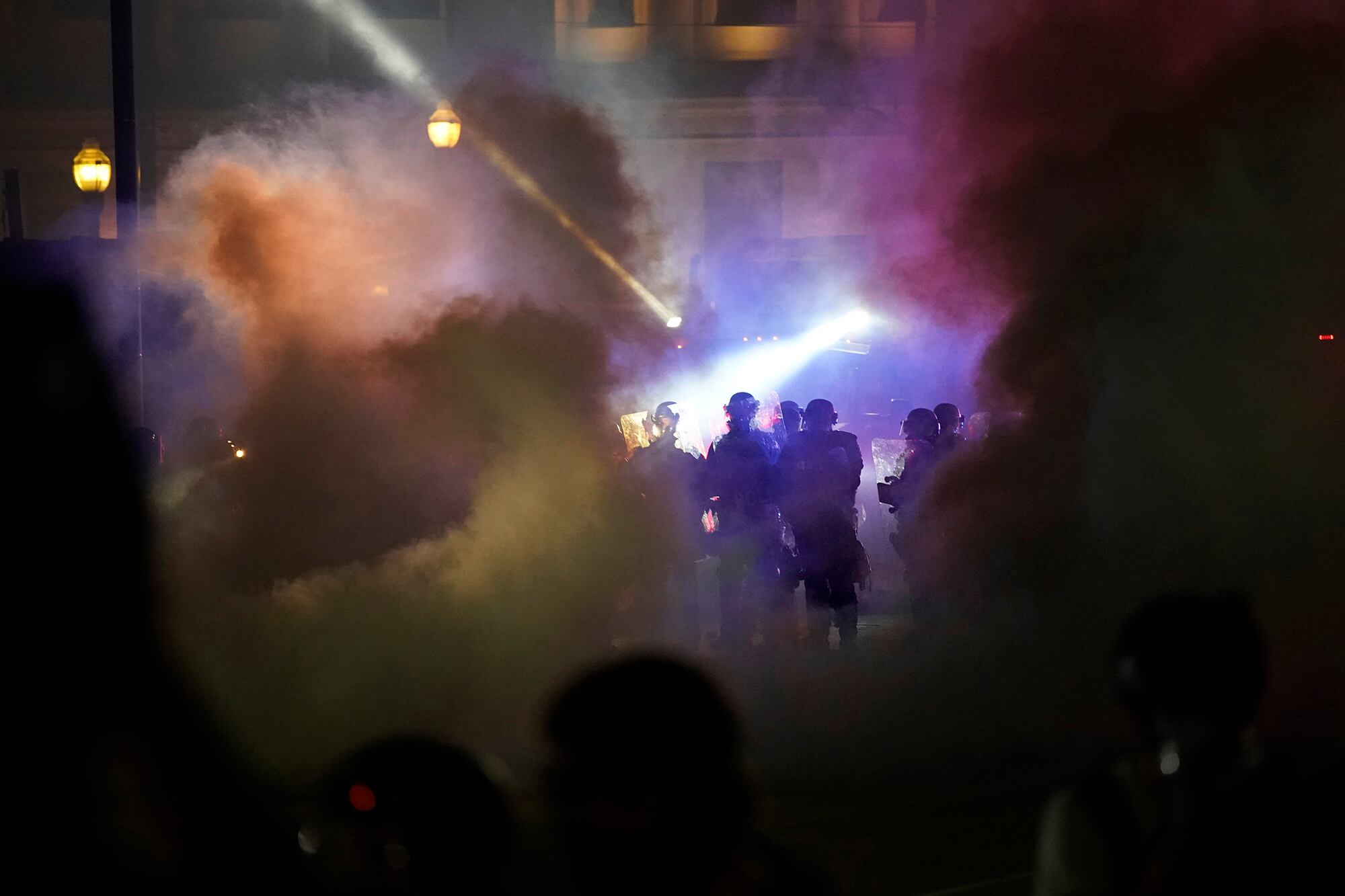 Police in riot gear clear the area in front of Kenosha County Courthouse during clashes with protesters late Tuesday, Aug. 25, 2020, in Kenosha, Wis.