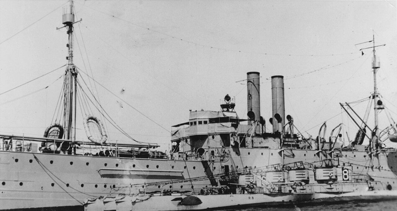 The U.S. Navy submarine tender USS Camden (AS-6) in San Diego Harbor during the early 1920s with four R-class submarines alongside. The outboard submarine is USS R-8 (SS-85). The inboard boat is USS R-6 (SS-83).