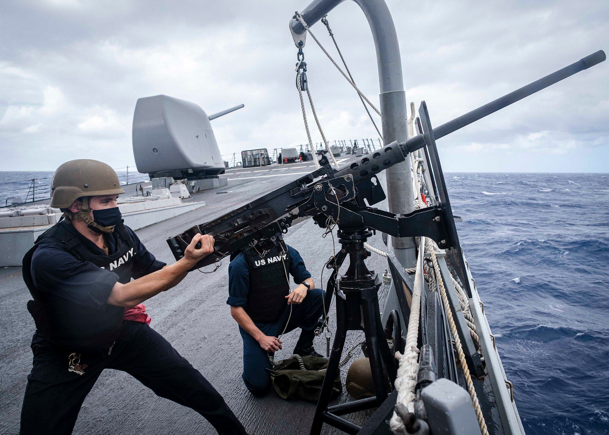 Fire Controlman 2nd Class Samuel Thomas "racks" an M2HB .50-caliber machine gun on the foc’s’le during a small craft attack team drill aboard the Arleigh Burke-class guided-missile destroyer USS John S. McCain (DDG 56) on Oct. 7, 2020, in the South China Sea.