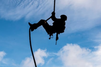 A Marine conducts fast-rope sustainment training on the flight deck of the forward-deployed amphibious assault ship USS America (LHA 6) on Aug. 23, 2020, in the Philippine Sea.