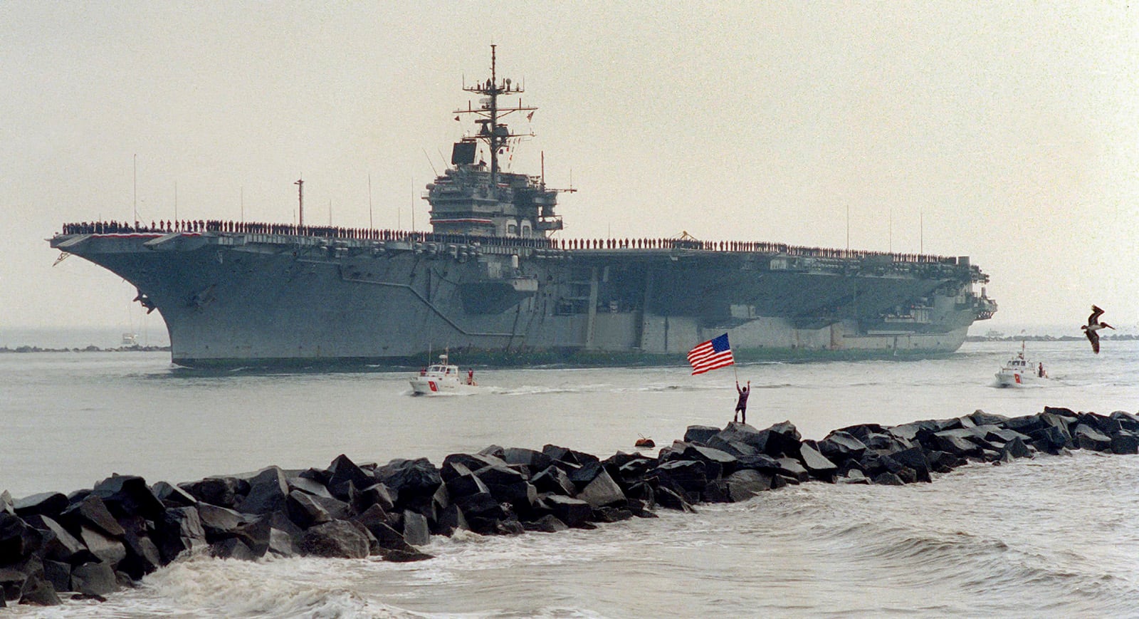 Matt Miller cutting a solitary figure on the South Jetties, waving Old Glory as the USS Saratoga enters the St. Johns River before swinging into Mayport Naval Station.